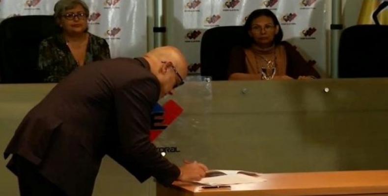 Venezuelan official Jorge Rodriguez signs an agreement requiring candidates to respect the results of the upcoming presidential election in May./Photo: RHC
