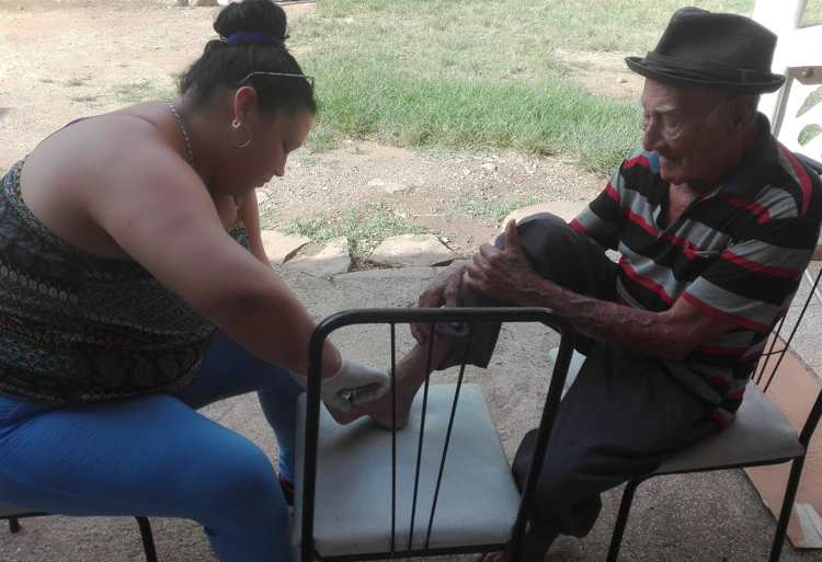 Danais Manrresa en la Casa de Abuelos Primero de septiembre enfrascada en la asistencia.