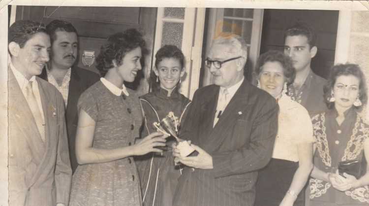 Flérida Isabel Galván promotora del equipo infantil local de beisbol “los Cubanitos” recibe la Copa del team vencedor. Entre los presentes la maestra Caridad (Kile) Villalba (segunda de derecha a izquierda), directora de la escuela cívico militar 44 de Sola.