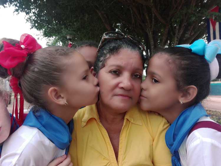 Marlenis Aguilar Verdecia rodeada de dos se sus alumnas. Foto Autora