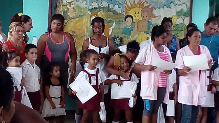 Niños reciben diploma de graduados de preescolar.