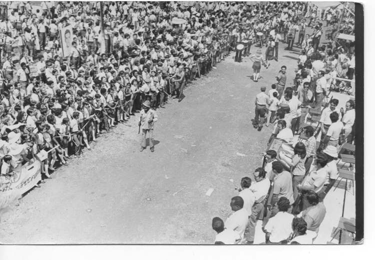 Actividad Político Cultural del concentrado estudiantil en Sola. (1977) Primer plano, lado derecho, dirigentes del territorio, senda izquierda estudiantes, centro fondo Banda estudiantil, desfilando delante con machete “José María el Haitiano”, personaje pintoresco y entrañable del poblado.