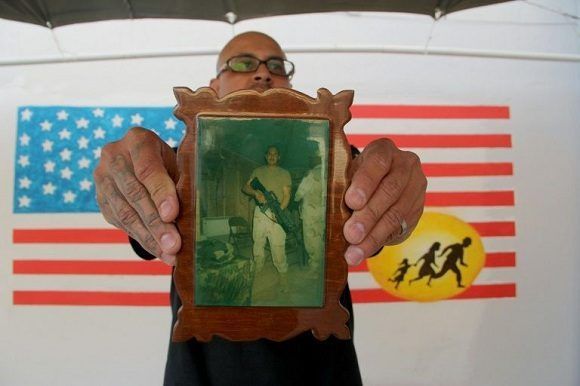 El veterano de guerra Ivan Ocon exhibe una foto de combate en un centro para los veteranos mexicanos deportados en Ciudad Juárez, el 19 de abril de 2017./Foto: Cubadebate