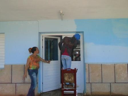 Jóvenes artistas en plena faena de pintura.